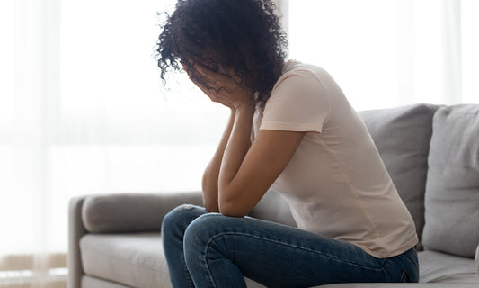 woman sitting on couch look sad