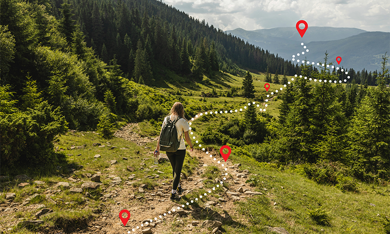 young woman hiking up a mountain to reach peak