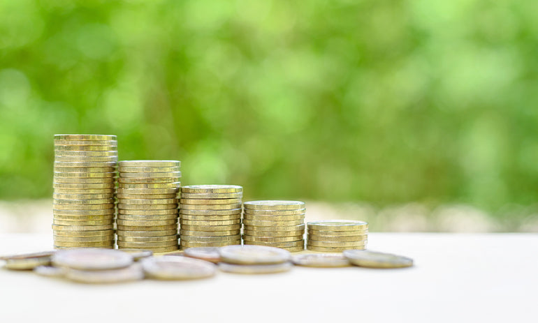 piles of coins on a white surface with a green background