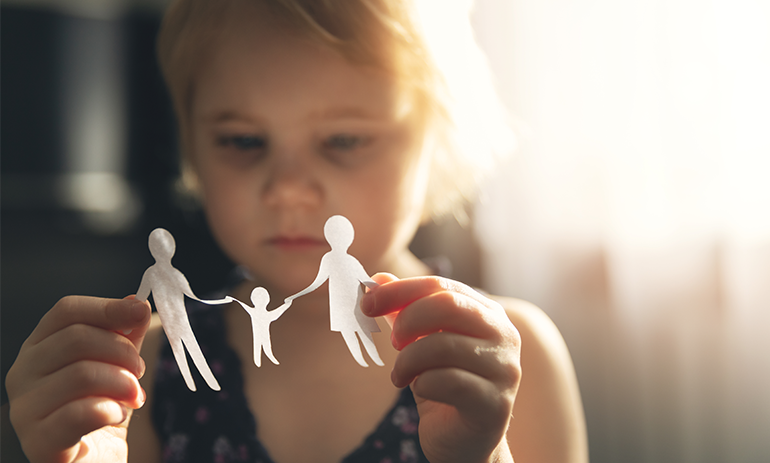 oung girl holding a paper cut out of a family