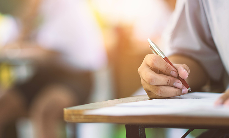 Woman's hand taking a written paper test.