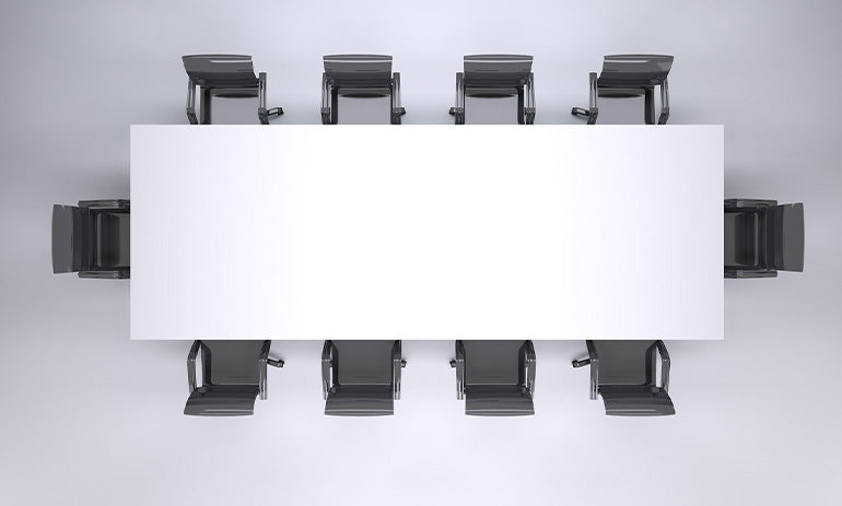 We're looking down at a boardroom table, with ten black chairs around a white rectangular table.