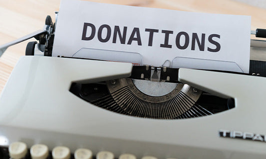 A typewriter with a piece of paper in it saying 'donations'|a typewriter typing the word 'donations' on a page|A typewriter with a page in it with the word donations typed on it