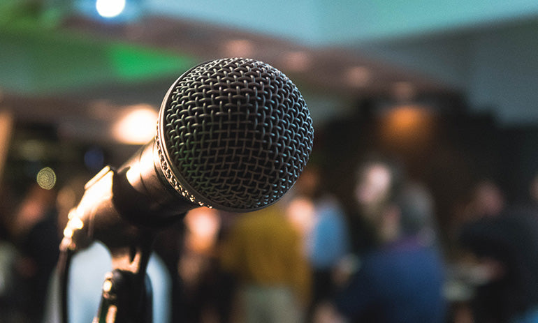 A microphone facing towards the camera, ready to be spoken into. It represents the Voices for Change survey.