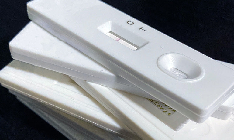A pile of white rapid antigen tests.