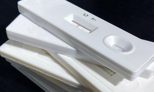 A pile of white rapid antigen tests.
