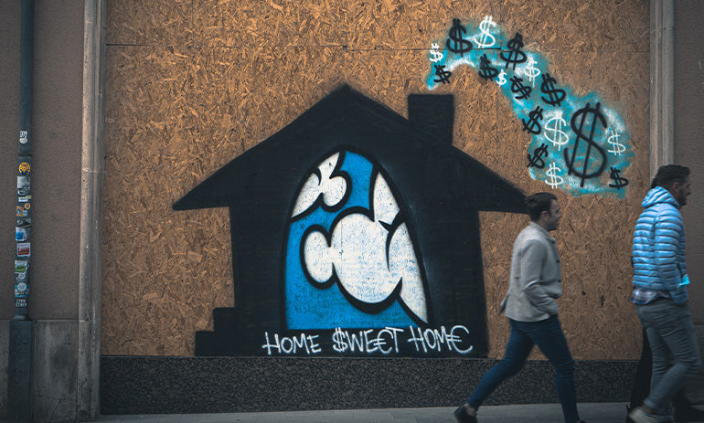 People walk past a graffiti mural of a house with dollar signs coming out of the chimney|