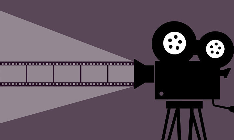A cartoon image of a video camera with film coming out, in purple and black.|