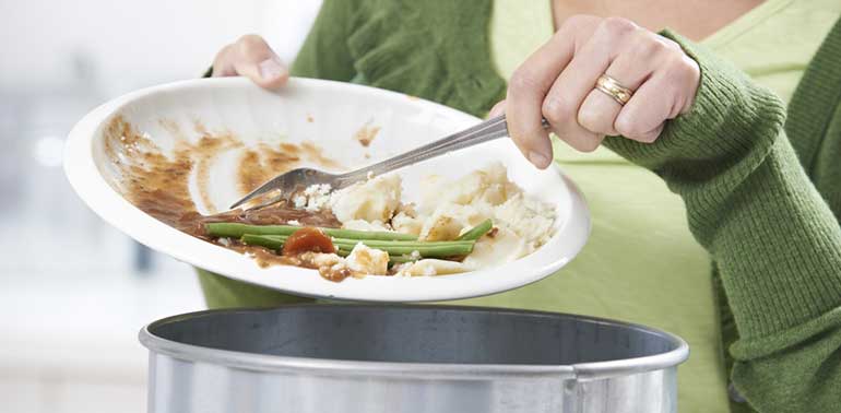 Woman scraping leftovers into bin