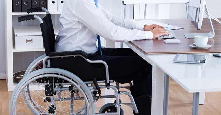 Man in a wheelchair at a desk