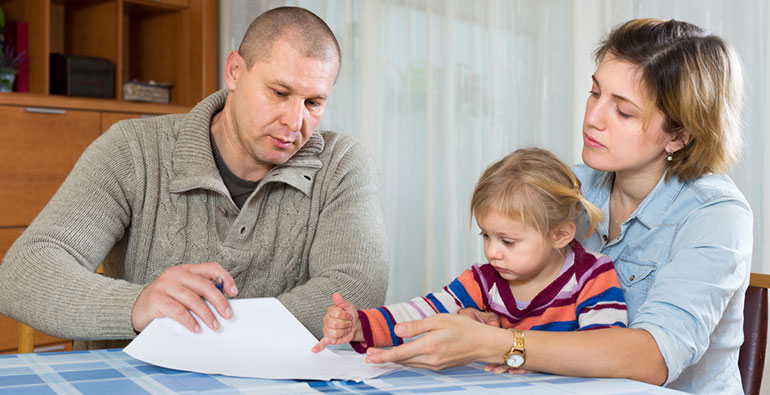 Poor family look at financial document at kitchen table