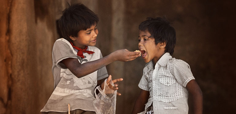 Boy feeding his brother