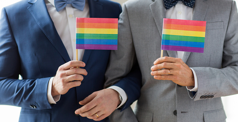 Two men holding rainbow flags
