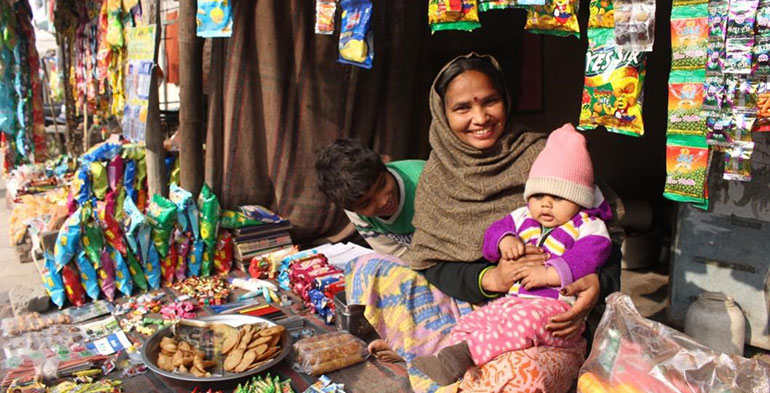 Female entrepreneur sitting in her stall with her children