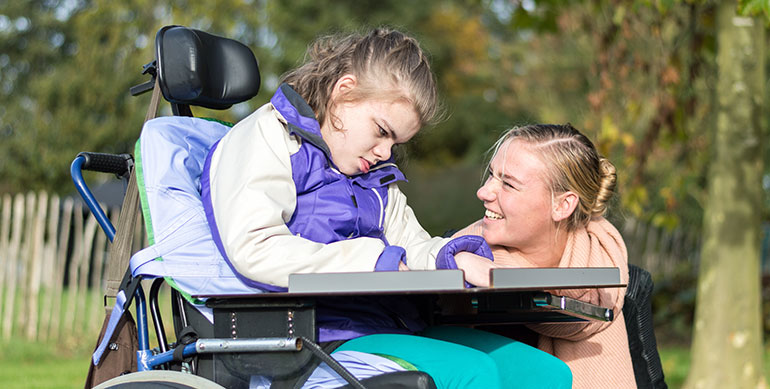 child with disability speaking with carer
