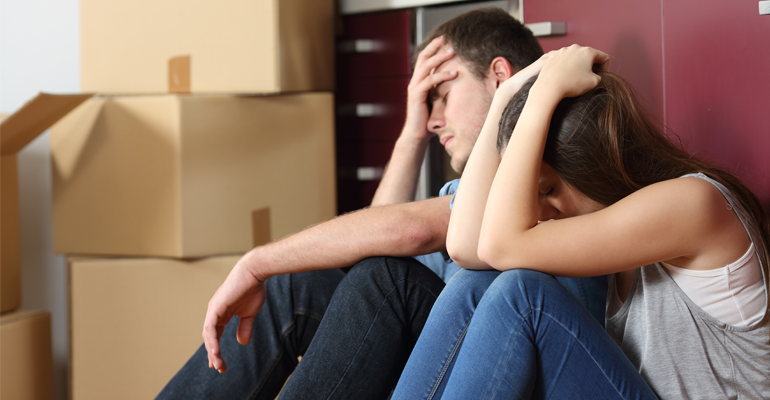 sad couple with moving boxes
