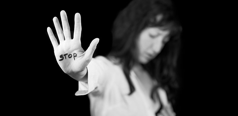 Woman with stop on her hand, calling for end to domestic violence