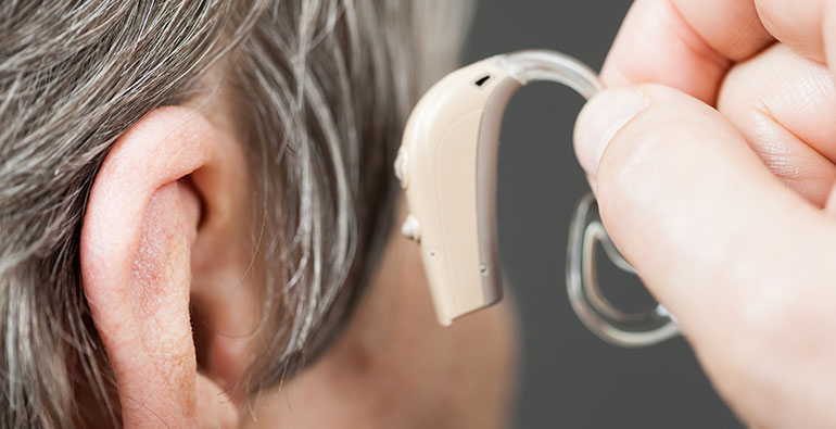 person putting a hearing aid on