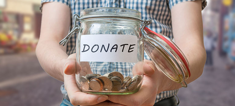 person holding out a donate jar