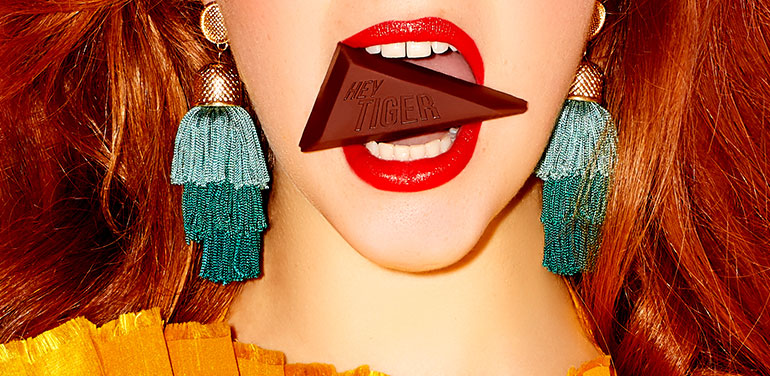 model with piece of Hey Tiger chocolate in her mouth