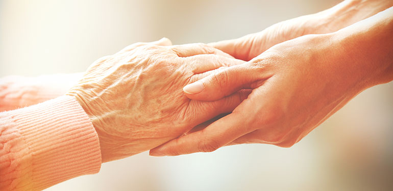young hands holding elderly persons hands