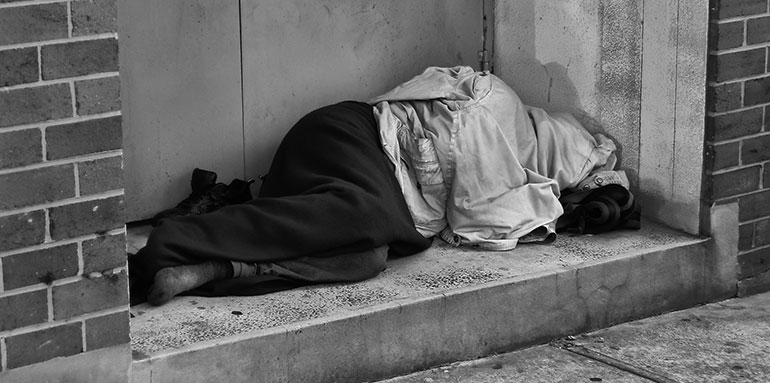 homeless person sleeping in a doorway