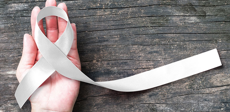 Hand holding a white ribbon