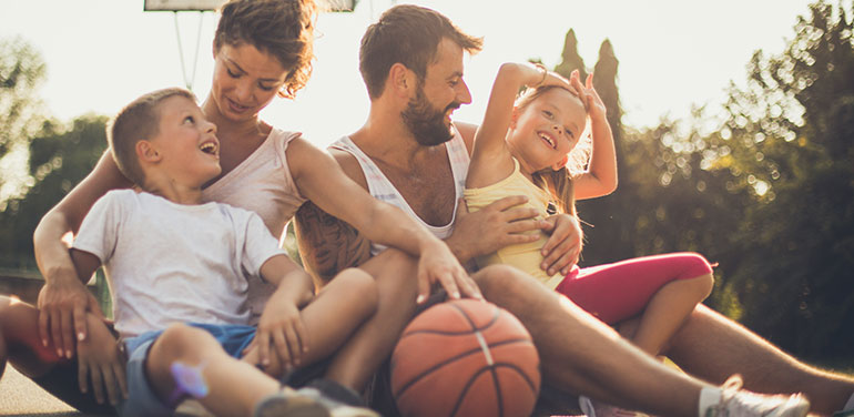 Family sitting together on a basketball court