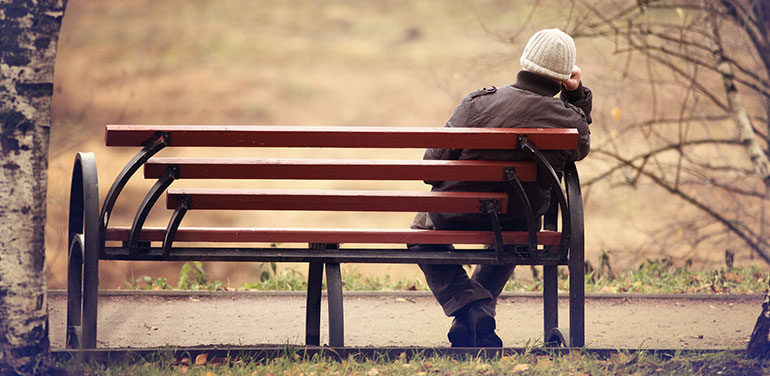 Lonely man sitting on a park bench