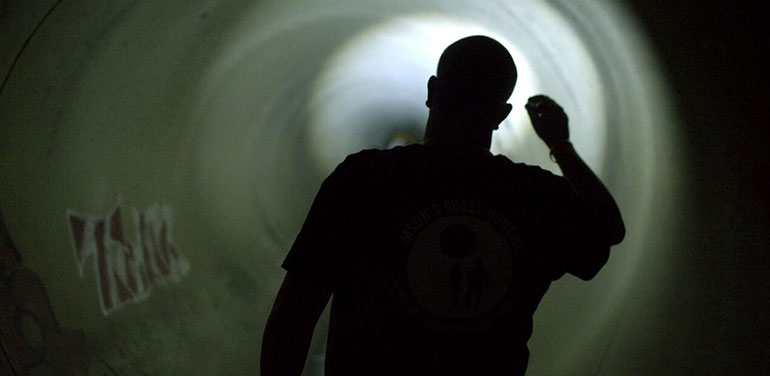 Jason King looking for ghosts in a tunnel