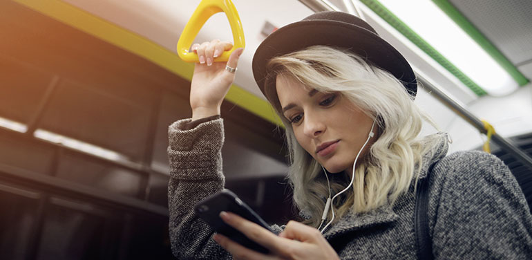 woman listening to podcast on train.