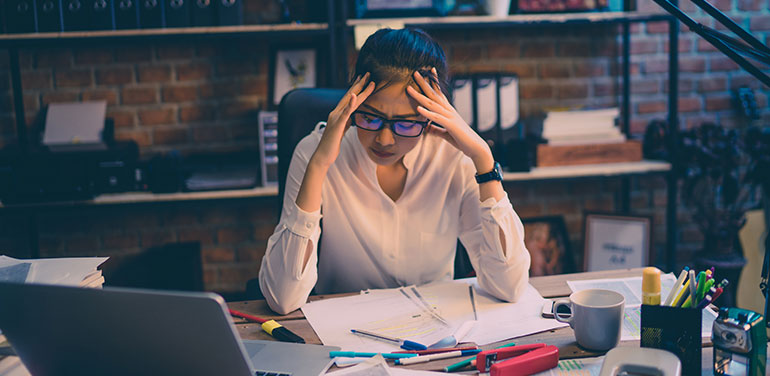 woman looking stressed at her desk