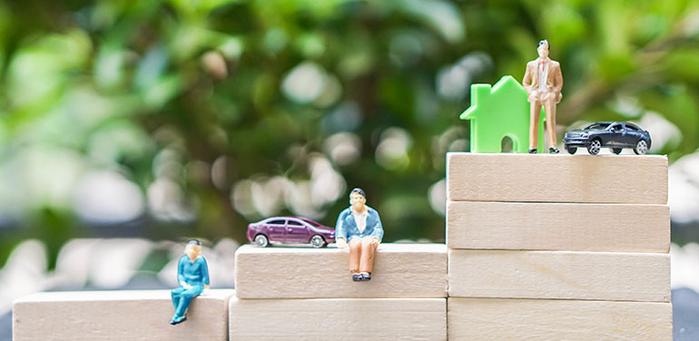 figures on different levels of wooden blocks, some with a house and car, showing inequality.