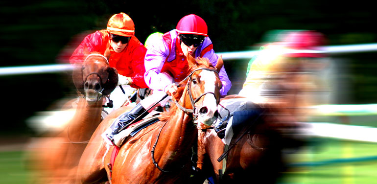 blurry photo of three jockeys riding horses in a race