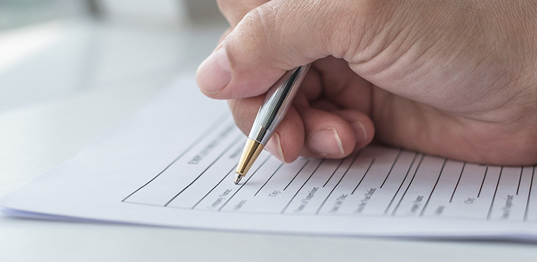 Close up of hand writing an application form