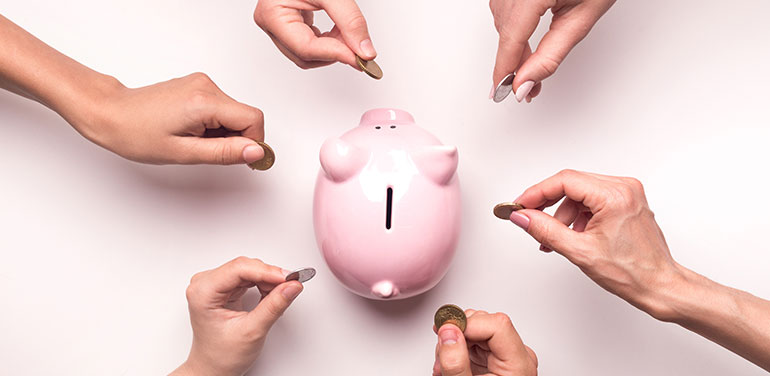 hands throwing coins in piggy bank for crowdfunding.