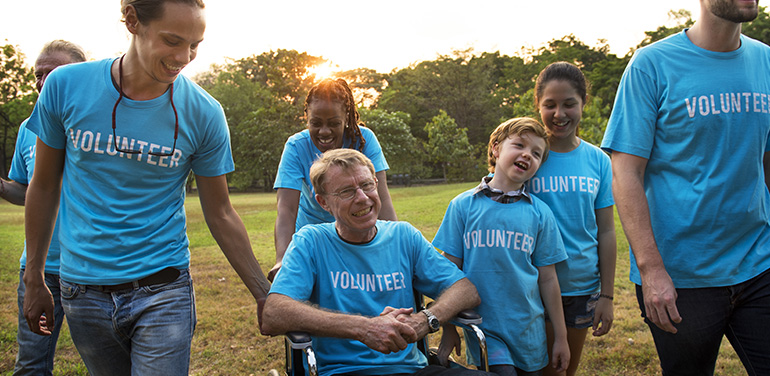 group of people in blue t-shirts with the words volunteer on them