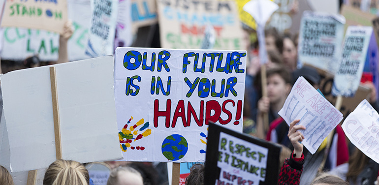 People with banners protest as part of a climate change march