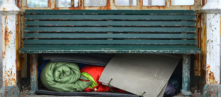 empty park bench with person's belongings underneath