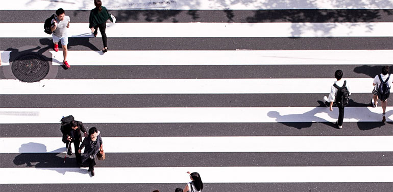 people walking across a zebra crossing