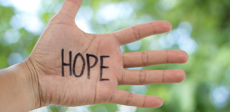the word hope written on someone's hand