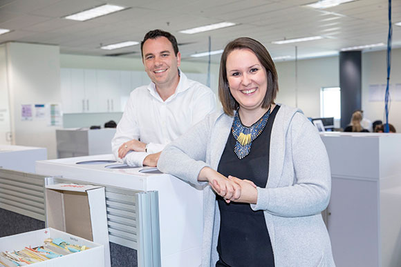 Jigsaw founders, Paul Brown and Laura O’Reilly, standing in an office.