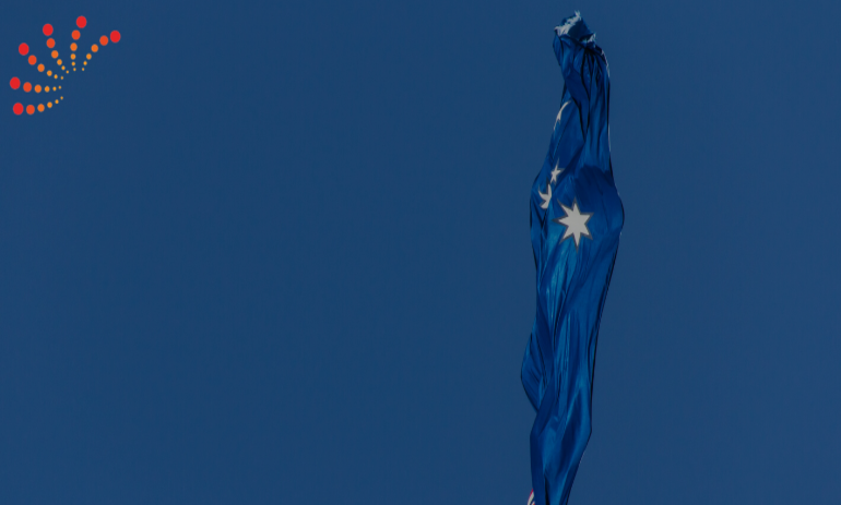 Thin stream of Australian flag blowing against blue backdrop