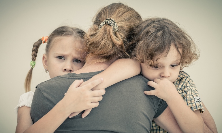 sad children hugging their mother