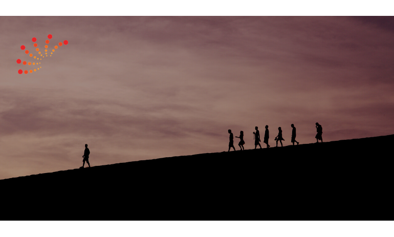 Image of people walking down a hill following a leader out in front