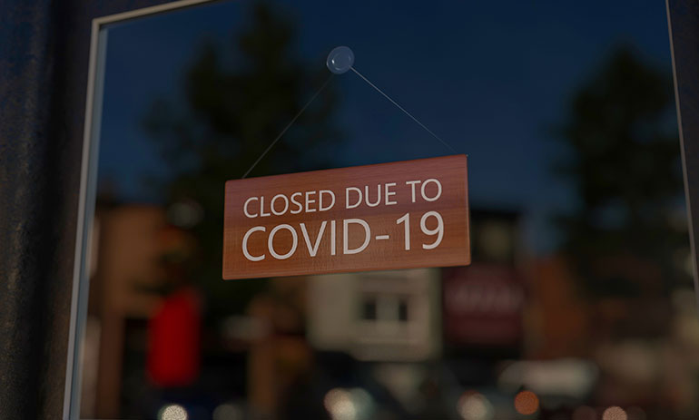 Sign in shop window saying closed for COVID