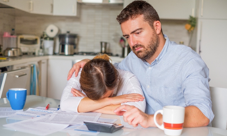 Husband consoling his wife about family financial trouble