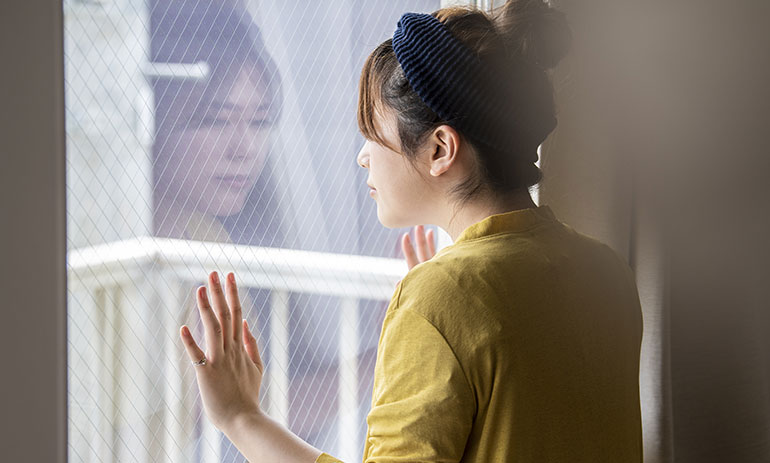 young Asian woman looking out of a window