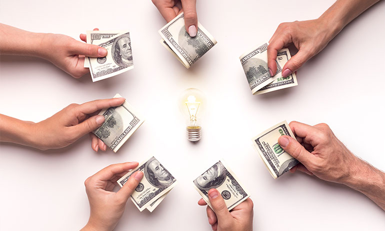 circle of hands holding money around a lightbulb