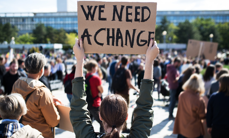 Person holding change protest sign